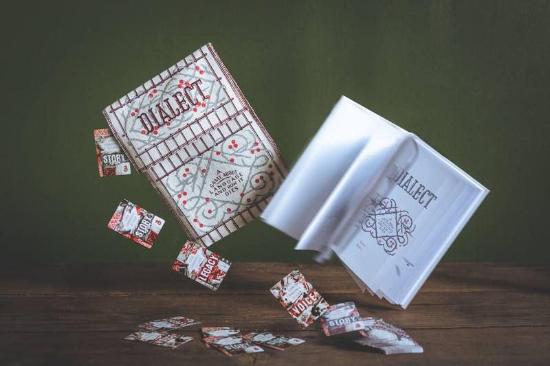 Dialect book and cards photographed above a wooden table