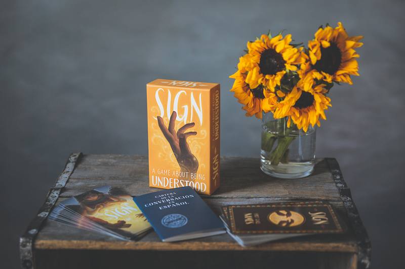 Sign box, card decks and booklet arranged on a wooden table