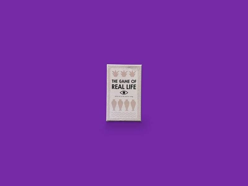 The Game of Real Life photographed on Bruno's purple Applied Games background